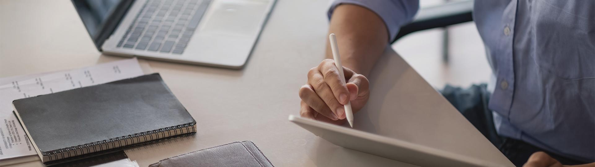someone drawing with a pen on a tablet