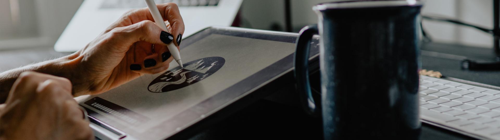 someone drawing a logo on a tablet
